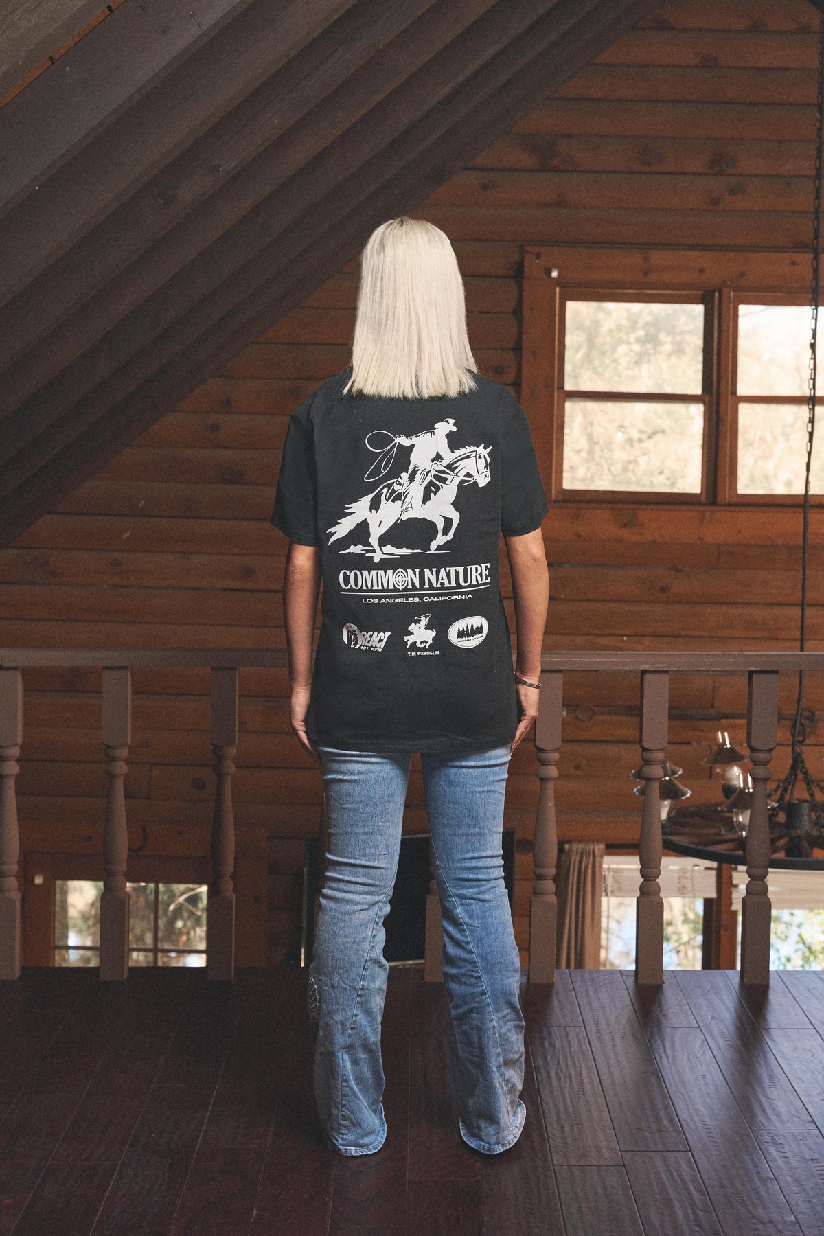 Woman wearing the Rider's Spirit Tee in black, back view