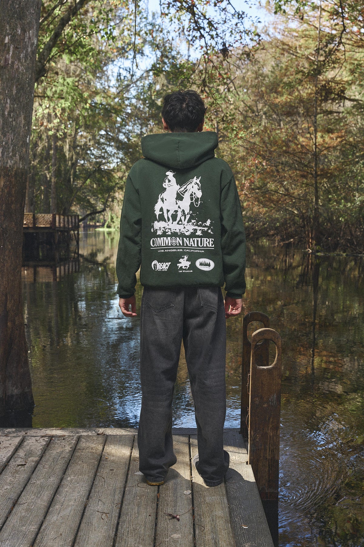Man wearing the Western Frontier Hoodie in forest green, back view