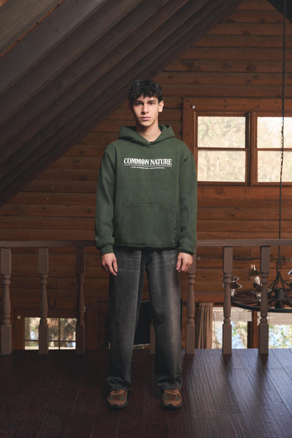 Man wearing the Rider's Spirit Hoodie in forest green, front view