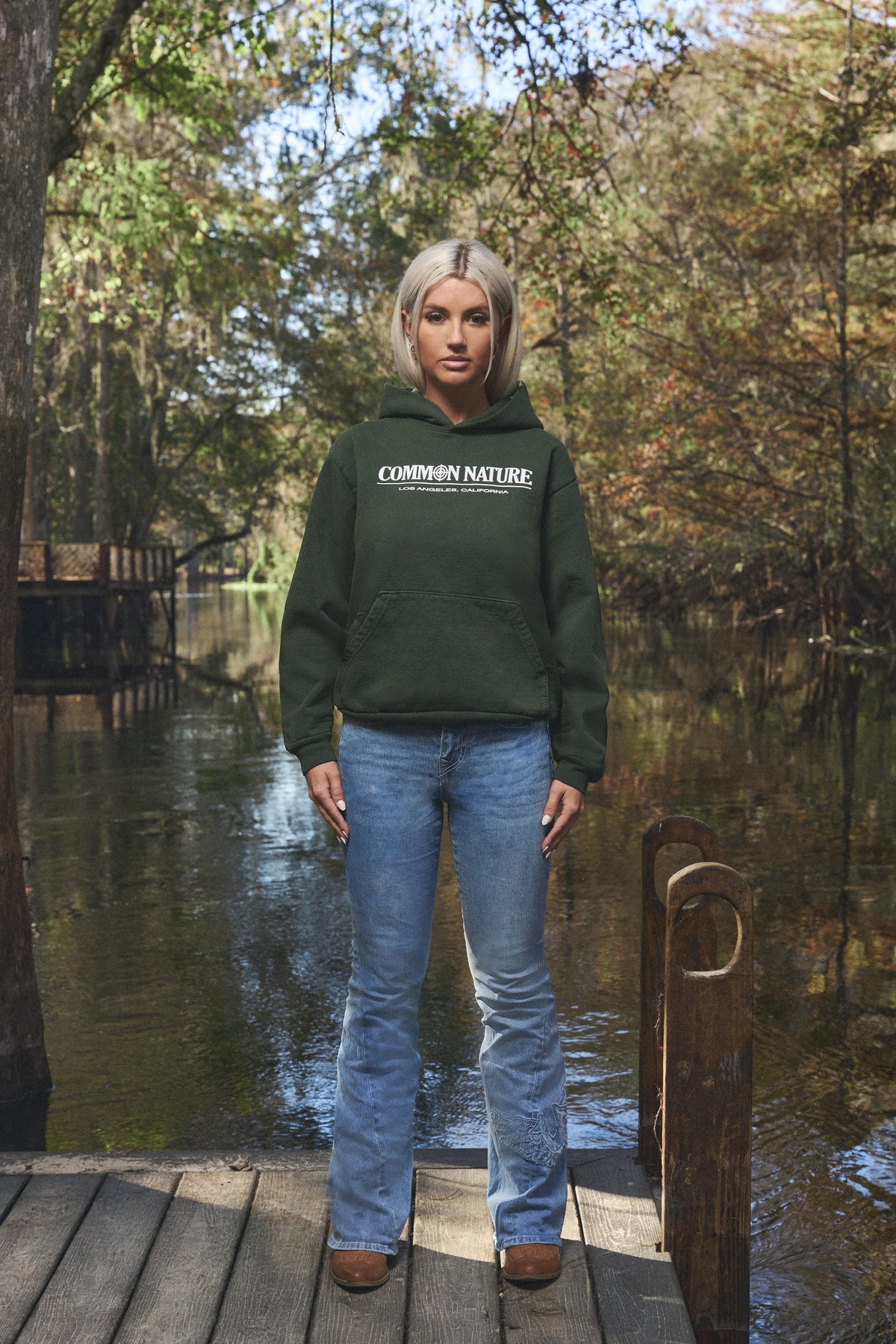 Woman wearing the Western Frontier Hoodie in forest green, front view
