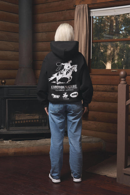 Woman wearing the Rider's Spirit Hoodie in black, back view