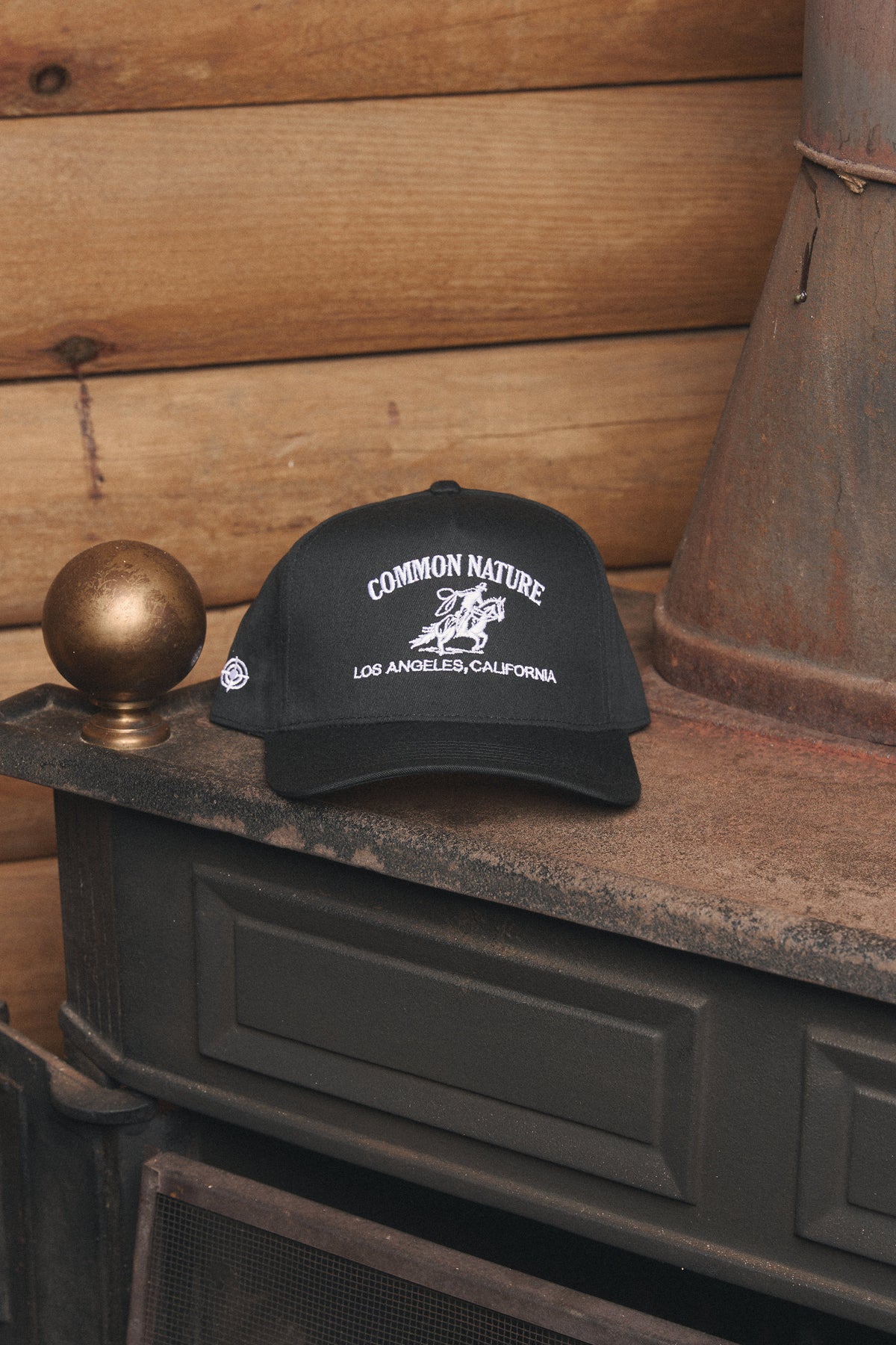 Rider's Hat in black resting on a vintage stove