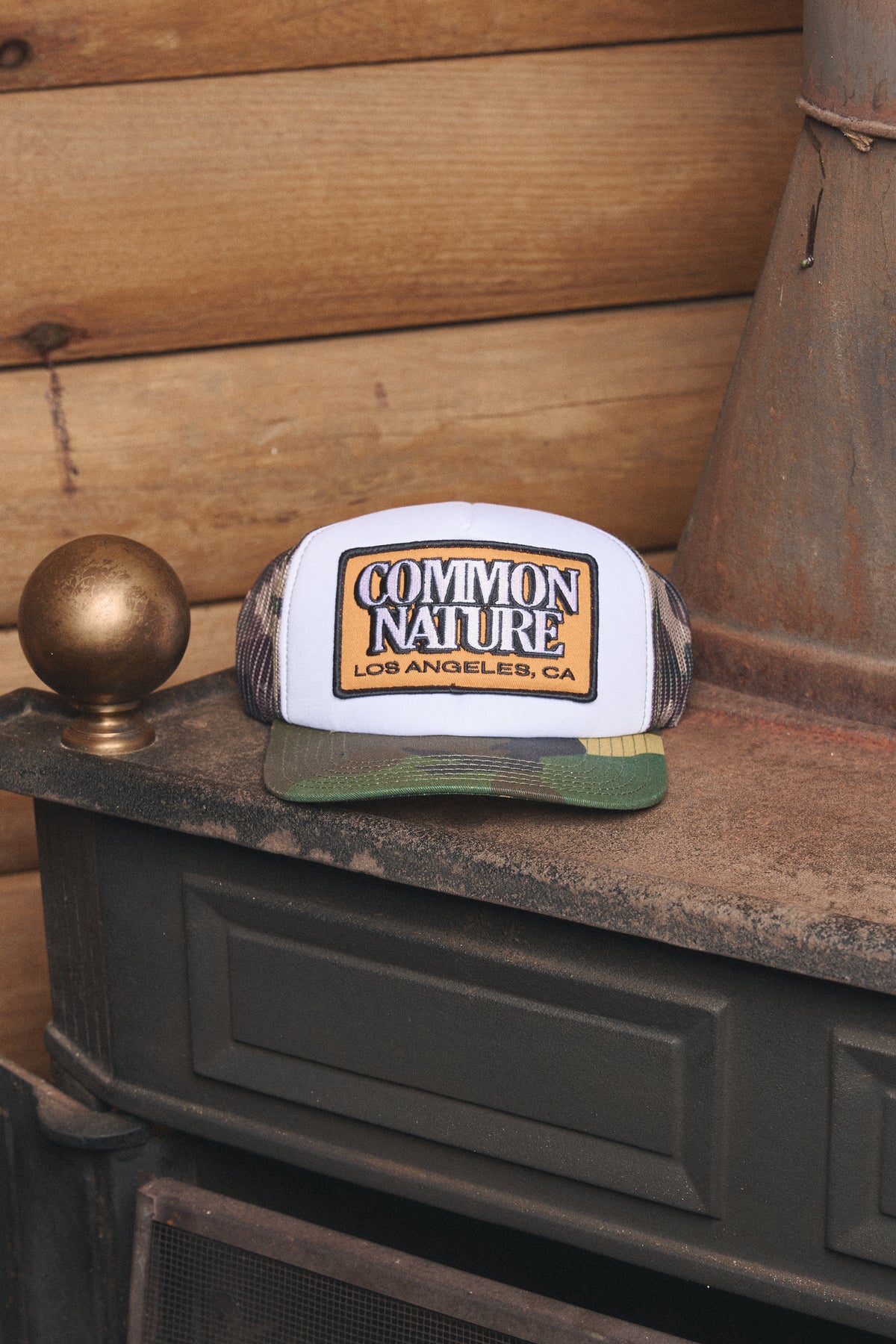 Common Patch Hat in camo resting on a vintage stove